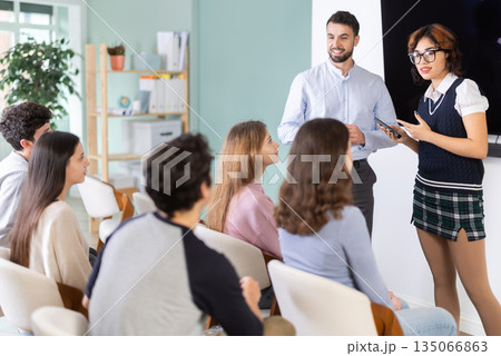 Male teacher and girl standing in front of listening students Male teacher and girl standing in front of listening students 135066863