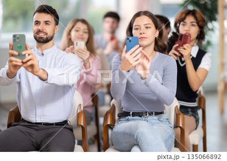 Students holding mobile phone and taking photos in classroom 135066892