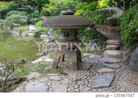 旧安田庭園の石灯籠と飛び石 回遊式庭園の園路と池の景観 旧安田庭園の石灯籠と飛び石 回遊式庭園の園路と池の景観 135067587