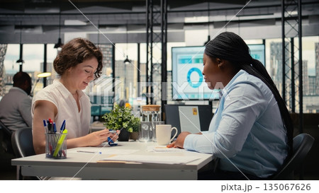 HR employee offers access key card to new hire after the interview, finalizing the onboarding process and registration after resume and CV approval. Welcoming to the team. Camera A. 135067626