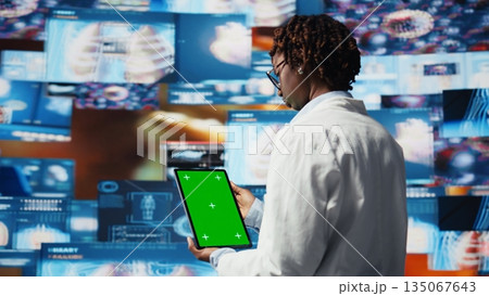 Scientist reviewing medical scans using green screen tablet, 360 degrees rotation. Woman in front of digital health dashboards backdrop analyzing human anatomy with mockup device, camera A close up 135067643