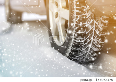Close-up of car wheels rubber tires in deep winter snow. Transportation and safety concept. 135068370