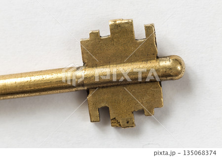 Close-up detail of old well-used steel key isolated on white copy space background. Safety and security concept. Close-up detail of old well-used steel key isolated on white copy space background. Safety and security concept. 135068374