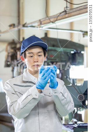 工場で旋盤加工品・フライス加工品を確認する男性作業員 135070531