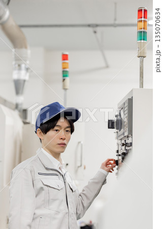工場の操作盤の前で働く男性作業員 135070634