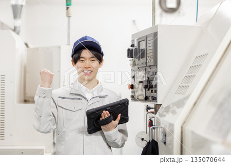 工場の操作盤の前で働く男性作業員 135070644