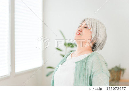 家のリビングで深呼吸するグレーヘアーのシニア女性 135072477