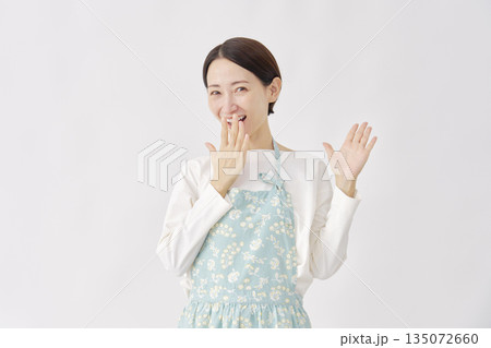 笑顔で驚くエプロンを着た女性　白背景 135072660