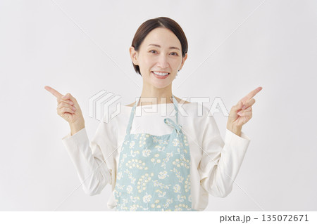 左右を指差すエプロンを着た女性 白背景 左右を指差すエプロンを着た女性 白背景 135072671