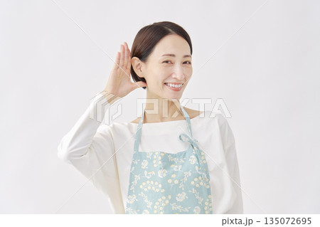 エプロンをつけた女性　聞くのジェスチャー　白背景 135072695