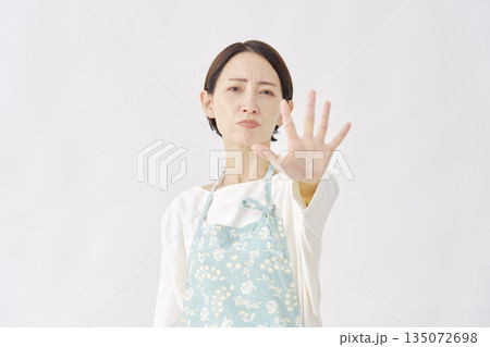 エプロンをつけた女性　ストップのジェスチャー　白背景 135072698