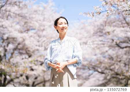 桜の木の下でストレッチをする若い女性　ライフスタイルイメージ 135072769