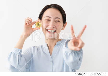 ビットコインを持っている女性　テクノロジーイメージ 135072792