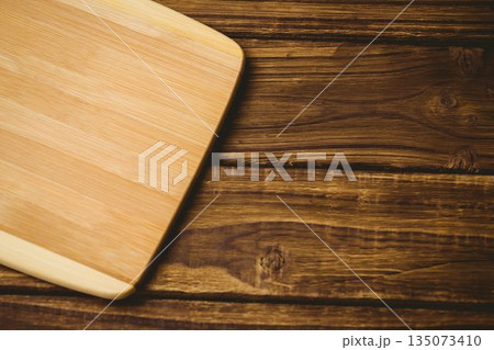 Chopping board on brown textured wooden flooring Chopping board on brown textured wooden flooring 135073410