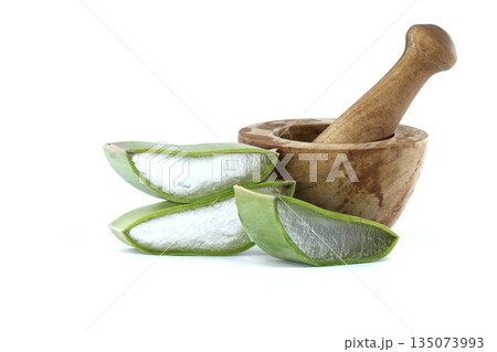 Fresh aloe vera slices and wooden mortar with pestle for natural remedies and skincare 135073993