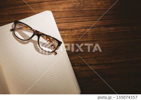 Eye glasses on blank book over wooden table 135074357