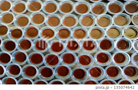 Rows of Indonesian Chocolate Agar-Agar Jelly in Plastic Cups Traditional Homemade Sweet Dessert Background Rows of Indonesian Chocolate Agar-Agar Jelly in Plastic Cups Traditional Homemade Sweet Dessert Background 135074642
