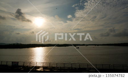 Golden Sunset Over Wide River with Silhouette of Old Bridge Railing in Belinyu Golden Sunset Over Wide River with Silhouette of Old Bridge Railing in Belinyu 135074782