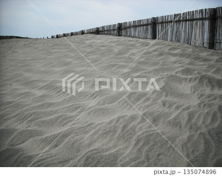 風が描いた砂の紋様と木製の柵 135074896