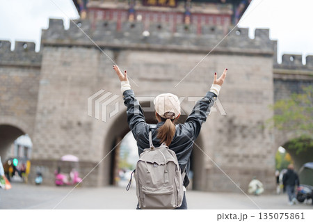 Happy woman traveler travel in Dujiangyan city. Tourist sightseeing Guanxian Ancient City near Chengdu. Landmark and popular for tourism attraction in Sichuan, China 135075861