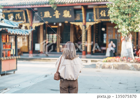 woman traveler travel in Chengdu city. Happy Tourist sightseeing in Daci Temple is a Buddhist temple . Famous Landmark for tourism attraction in Sichuan, China 135075870