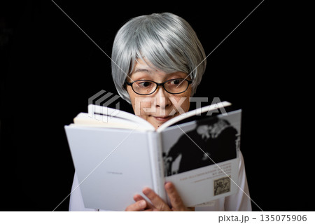 読書をする黒ぶち眼鏡をかけたシニア女性 読書をする黒ぶち眼鏡をかけたシニア女性 135075906