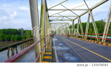 Wide View of Steel Bridge Deck with Puddles and Parallel Old Wooden Bridge 135076083