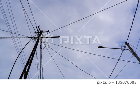 Electrical Power Lines and Street Light Against Overcast Sky 135076085