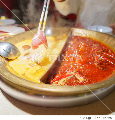 Woman tourist eating traditional hot pot or mala spicy soup in restaurant. Popular foods for tourist eating in Chengdu, Chongqing and China. Chinese Asia and Sichuan foods concept Woman tourist eating traditional hot pot or mala spicy soup in restaurant. Popular foods for tourist eating in Chengdu, Chongqing and China. Chinese Asia and Sichuan foods concept 135076260