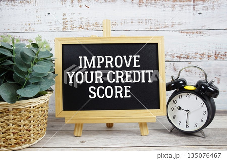Improve Your Credit Score text written on blackboard with alarm clock on wooden background 135076467