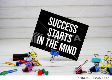 Success Starts In The Mind text on paper card with stationary on wooden background Success Starts In The Mind text on paper card with stationary on wooden background 135076532
