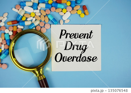 Prevent Drug Overdose with Various Colored Pills and magnifying glass on blue background 135076548