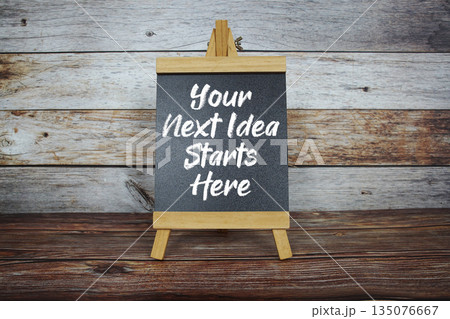 Your Next Idea Starts Here text on easel blackboard on wooden background 135076667