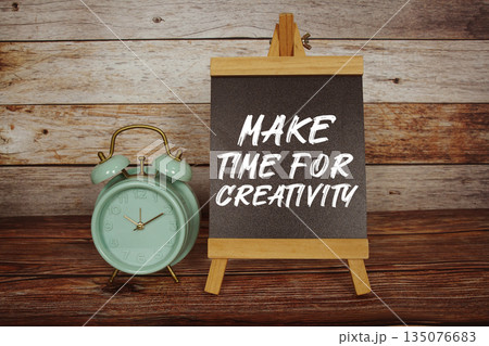 Make Time For Creativity text on easel blackboard with alarm clock on wooden background 135076683