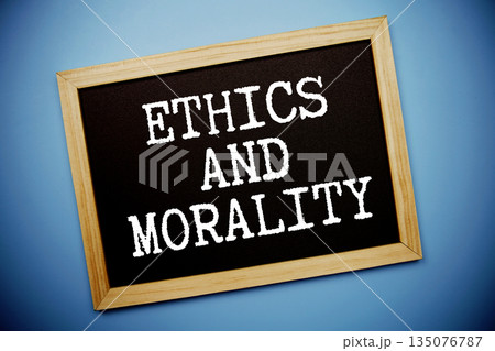 Ethics And Morality text written on chalkboard flat lay on blue background Ethics And Morality text written on chalkboard flat lay on blue background 135076787