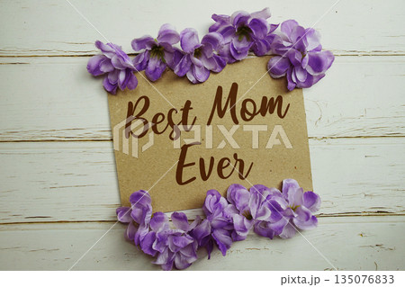 Best Mom Ever text written on paper card with flower decoration on wooden background Best Mom Ever text written on paper card with flower decoration on wooden background 135076833