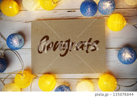 Congrats text with LED cotton balls decorate on wooden background Congrats text with LED cotton balls decorate on wooden background 135076844