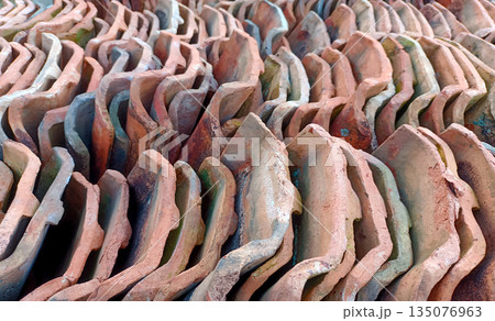 Rows of Stacked Traditional Terracotta Roof Tiles, Clay Construction Material Pattern 135076963