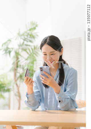 スマホとクレジットカードを持つ女性 スマホとクレジットカードを持つ女性 135077112