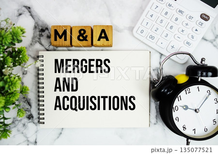 M and A Mergers and Acquisitions text with calculator and alarm clock on marble background M and A Mergers and Acquisitions text with calculator and alarm clock on marble background 135077521