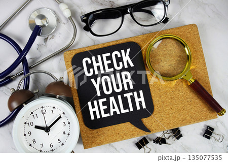 Check Your Health text with alarm clock, calculator and stethoscope on marble background 135077535
