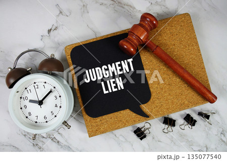 Judgment Lien text on speech bubble with alarm clock and wooden gavel on marble background 135077540