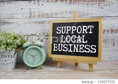 Support Local Business text written on blackboard with alarm clock on wooden background 135077572