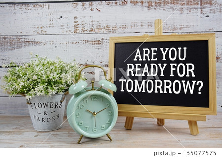 Are You Ready For Tomorrow? text written on blackboard with alarm clock on wooden background 135077575