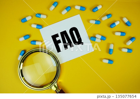 FAQ with medicine capsule and magnifying glass on yellow background 135077654