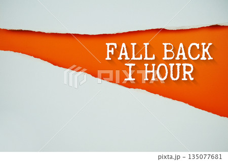 Fall Back 1 Hour text on orange with white paper torn ripped of horizontal 135077681