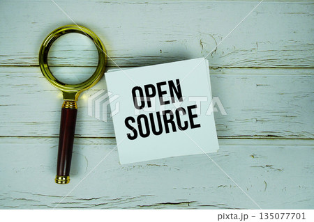 Open Source text with magnifying glass on wooden background 135077701