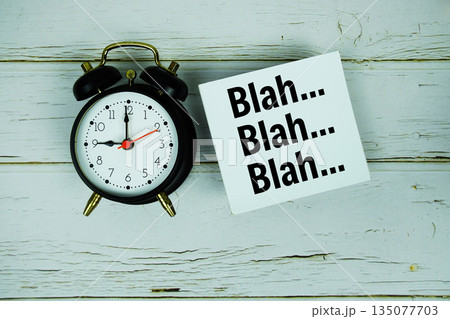 Blah Blah Blah text with alarm clock on wooden background Blah Blah Blah text with alarm clock on wooden background 135077703