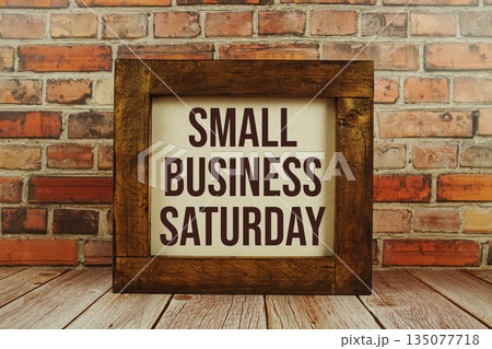 Small Business Saturday text written on wooden board standing with old brick wall background Small Business Saturday text written on wooden board standing with old brick wall background 135077718