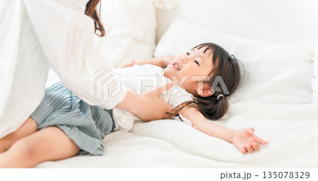 ベッドで娘を寝かしつける母親(子育て,育児) ベッドで娘を寝かしつける母親(子育て,育児) 135078329